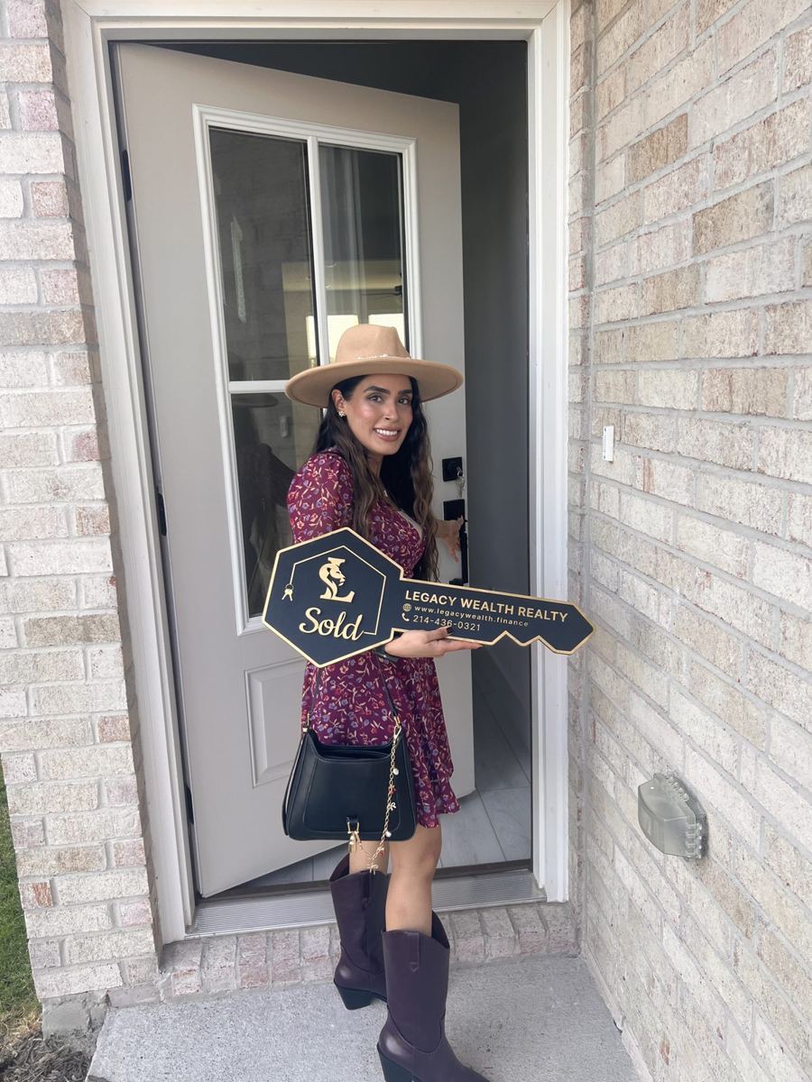 Client holding a Legacy Wealth Realty sold key at her new front door