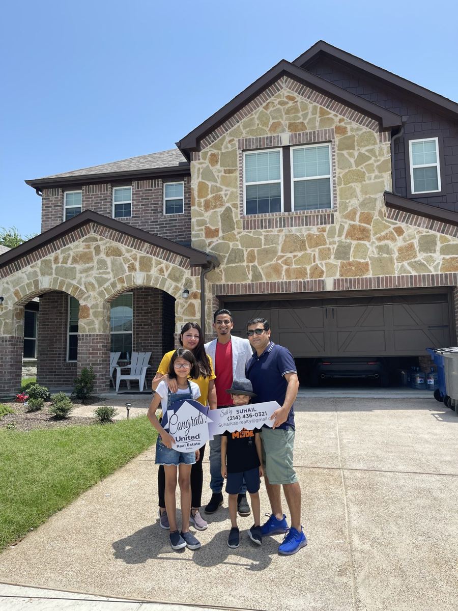 Family in front of their new two-story home