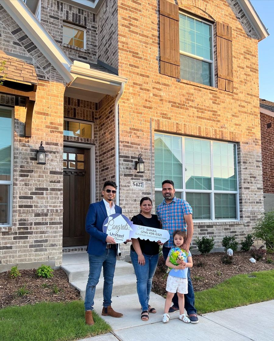 Family with Suhail in front of their new brick home